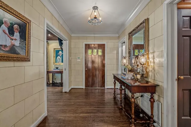 a view of a hallway with wooden floor and a livingroom