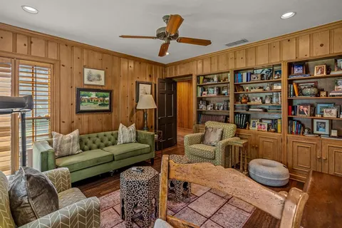 a living room with furniture a rug and a book shelf