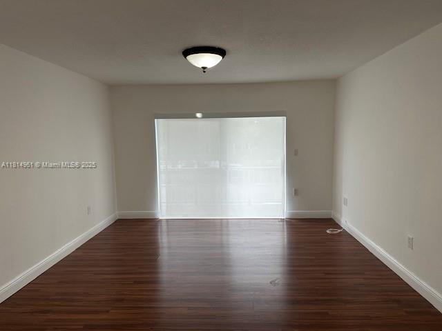 5400 Southwest 77th Court, Unit 2R Miami, FL 33155 - Photo 11 of 18 a view of an empty room with wooden floor and a window