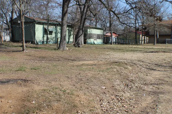 a front view of a building with large trees