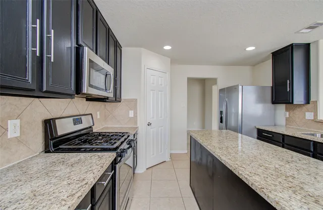 a kitchen with stainless steel appliances granite countertop a sink and a stove