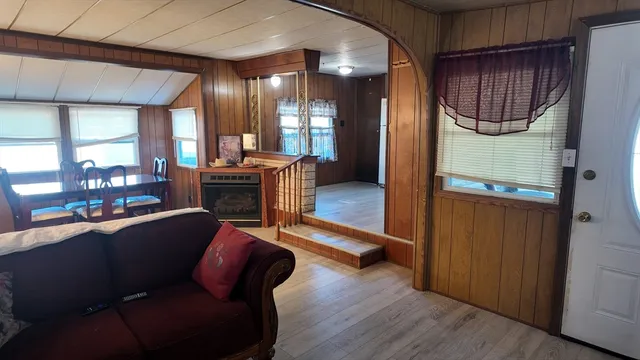a living room with furniture a fireplace and a floor to ceiling window