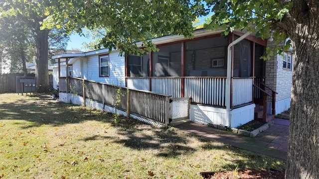 a view of a house with a large tree and wooden fence