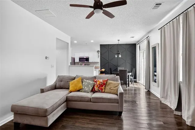 a living room with furniture and a wooden floor