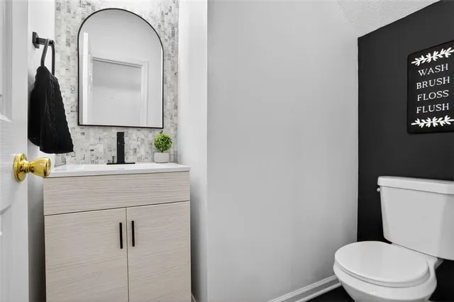 a bathroom with a toilet sink and mirror