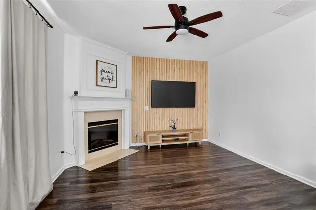 a view of a livingroom with wooden floor a fireplace and entryway