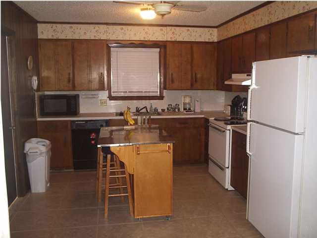 4391 Stephens Road Pace, FL 32571 - Photo 6 of 11 a kitchen with a sink a refrigerator and chairs