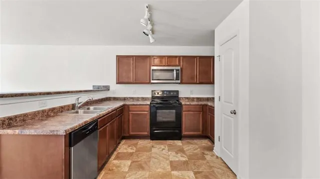 a kitchen with stainless steel appliances granite countertop a sink stove and refrigerator