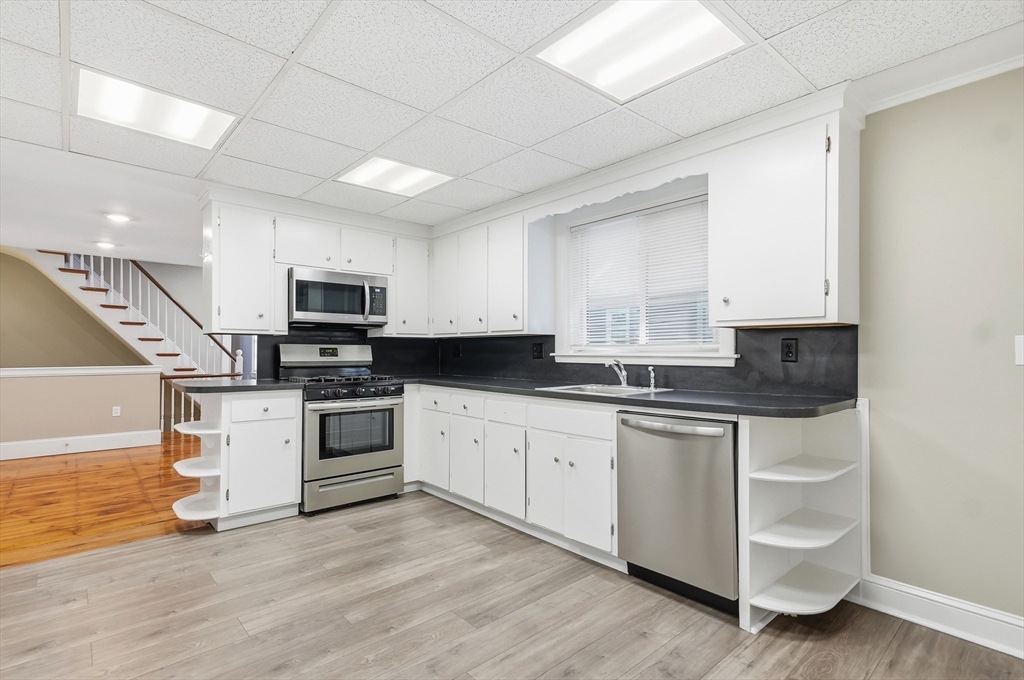 163-165 Chestnut Street Waltham, MA 02453 - Photo 11 of 41 a kitchen with granite countertop white cabinets and white appliances