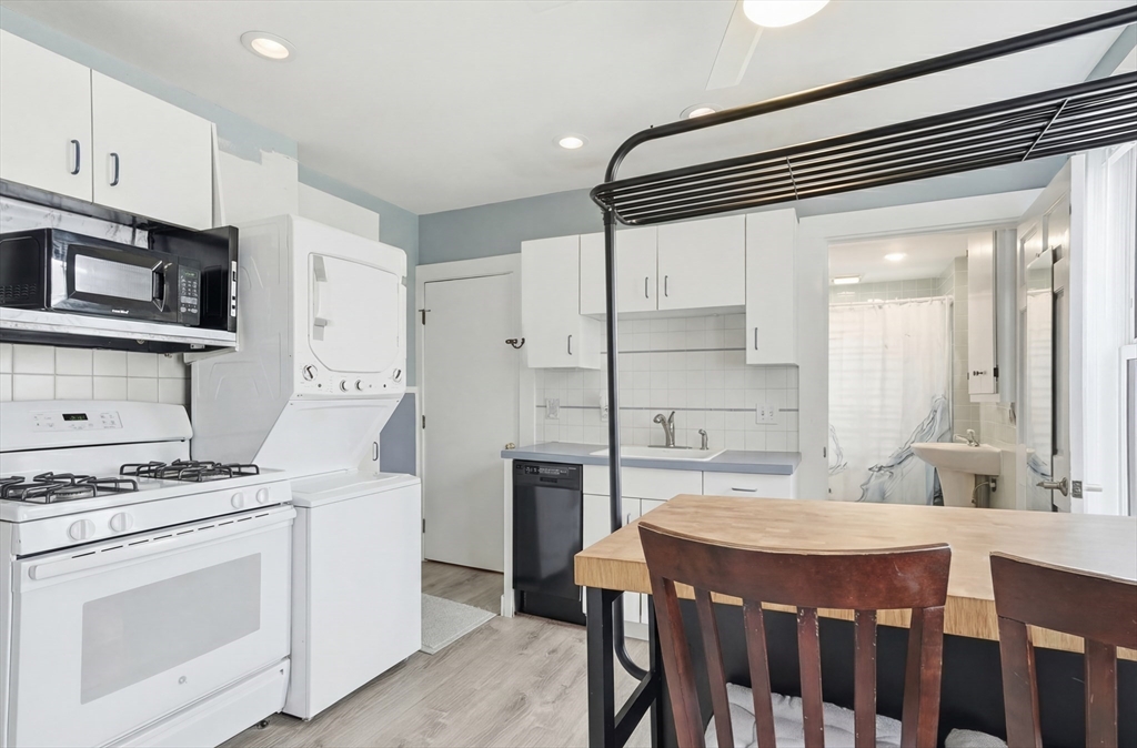 163-165 Chestnut Street Waltham, MA 02453 - Photo 24 of 41 a kitchen with stainless steel appliances kitchen island a table chairs sink and cabinets