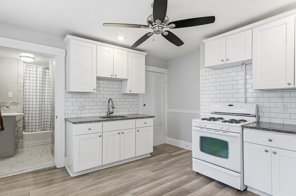 163-165 Chestnut Street Waltham, MA 02453 - Photo 7 of 41 a kitchen with cabinets stainless steel appliances a sink and wooden floor