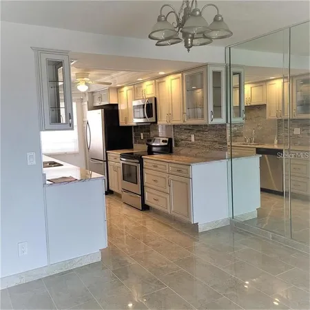 a kitchen with stainless steel appliances a stove a refrigerator and a sink