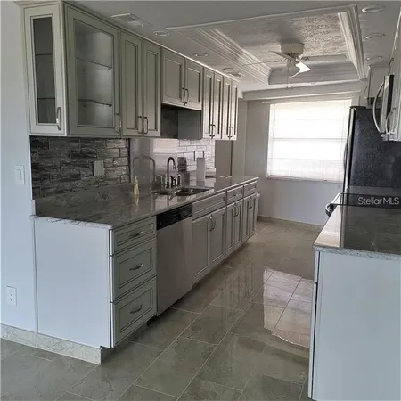 a kitchen with stainless steel appliances granite countertop a sink stove and microwave