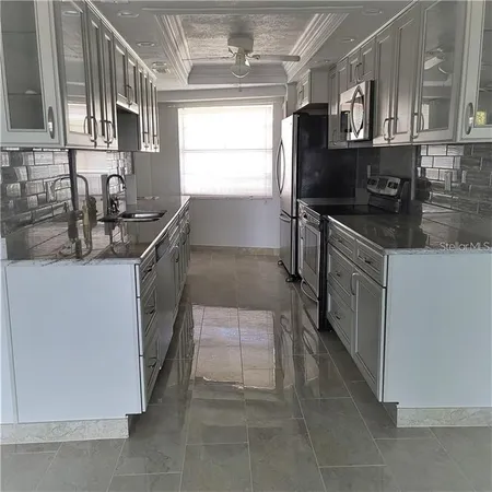 a kitchen with stainless steel appliances granite countertop a sink stove and refrigerator