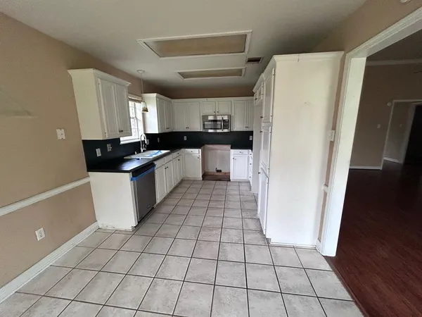 a kitchen with stainless steel appliances a refrigerator sink and cabinets