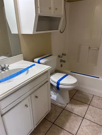 a bathroom with a granite countertop toilet and a sink