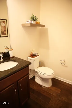 a bathroom with a granite countertop toilet sink and mirror