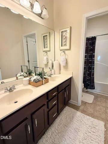 a bathroom with double vanity sinks a toilet a mirror and shower