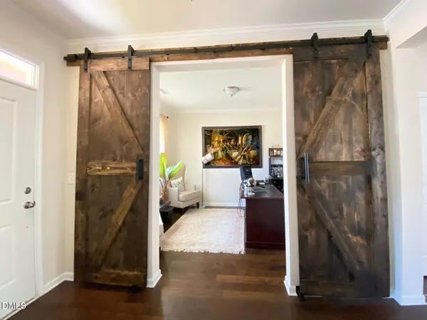 a walk in closet with wooden floor