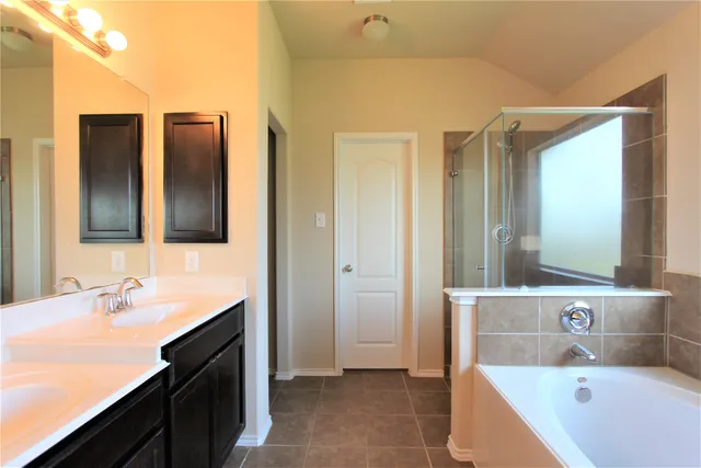 a bathroom with a tub sink and mirror