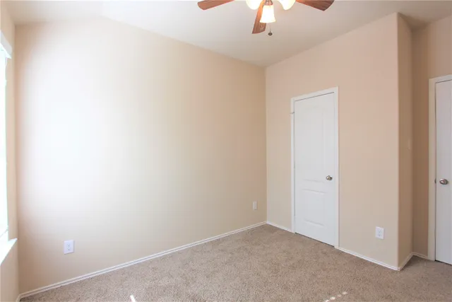 an empty room with a chandelier fan