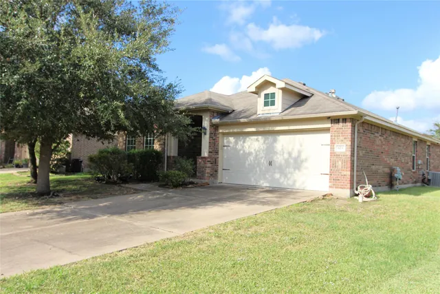 a view of a house with a backyard and a tree
