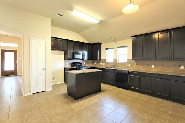 a kitchen with stainless steel appliances granite countertop a refrigerator and a sink