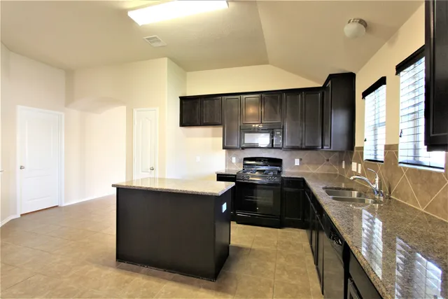 a kitchen with stainless steel appliances a sink stove and microwave