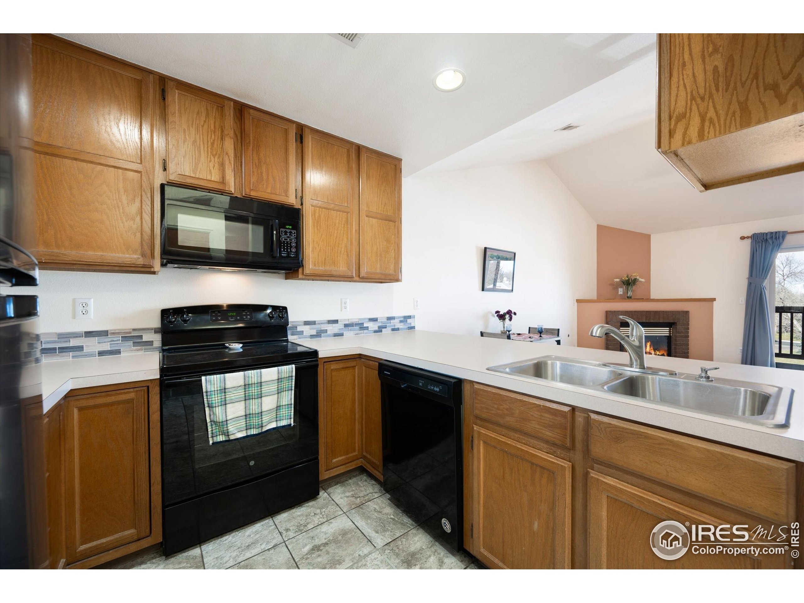 2960 West Stuart Street, Unit 304 Fort Collins, CO 80526 - Photo 9 of 28 a kitchen with stainless steel appliances granite countertop wooden cabinets a stove top oven a sink and dishwasher