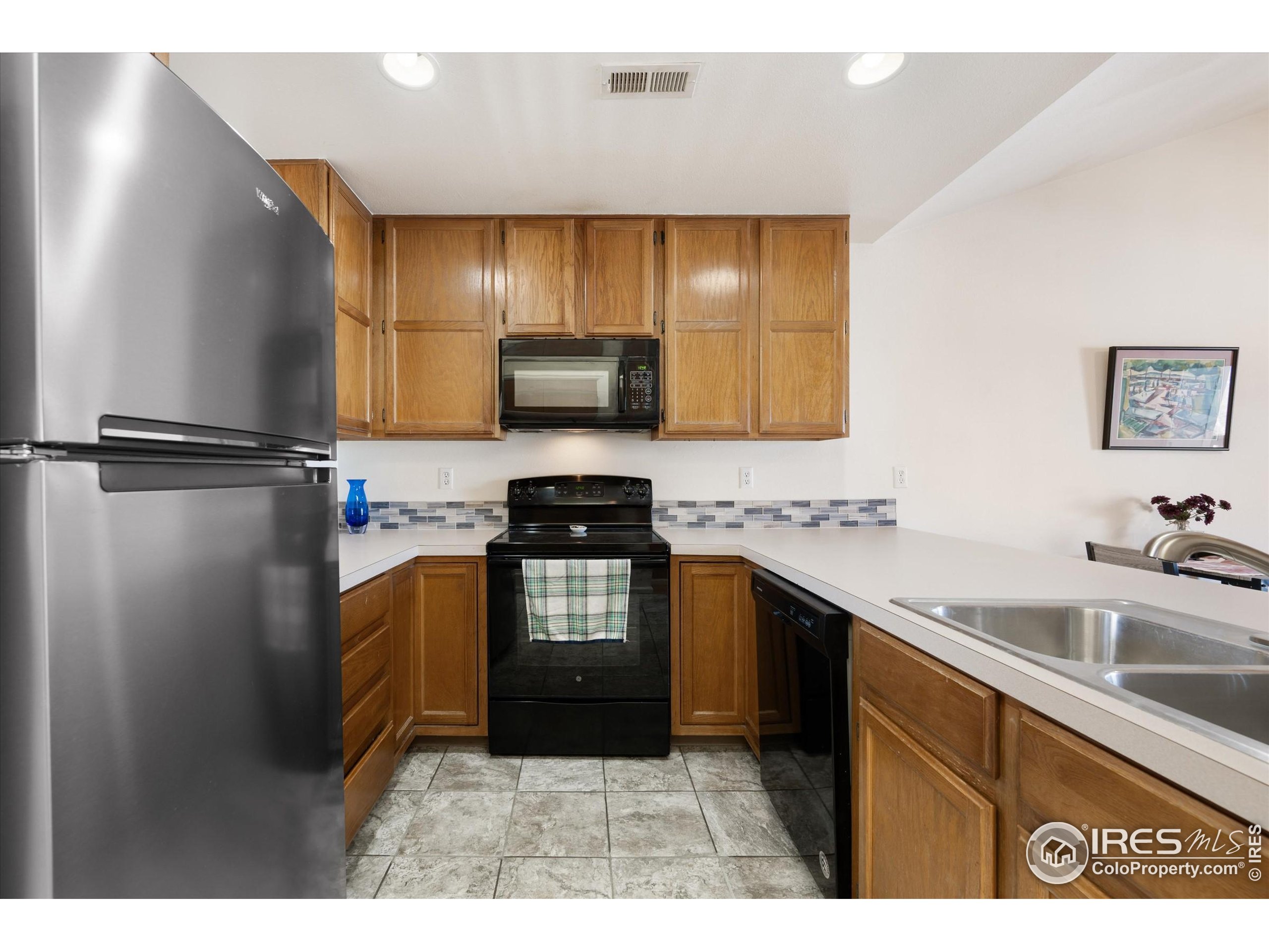 2960 West Stuart Street, Unit 304 Fort Collins, CO 80526 - Photo 10 of 28 a kitchen with stainless steel appliances granite countertop a sink stove and refrigerator