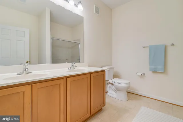a bathroom with a granite countertop sink toilet and mirror