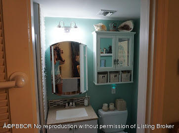 6590 North Ocean Boulevard, Unit 8 Ocean Ridge, FL 33435 - Photo 14 of 24 a bathroom with a toilet a sink and mirror