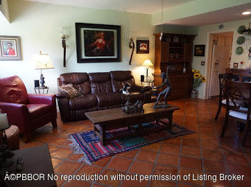 6590 North Ocean Boulevard, Unit 8 Ocean Ridge, FL 33435 - Photo 23 of 24 a living room with furniture a rug and paintings on the wall