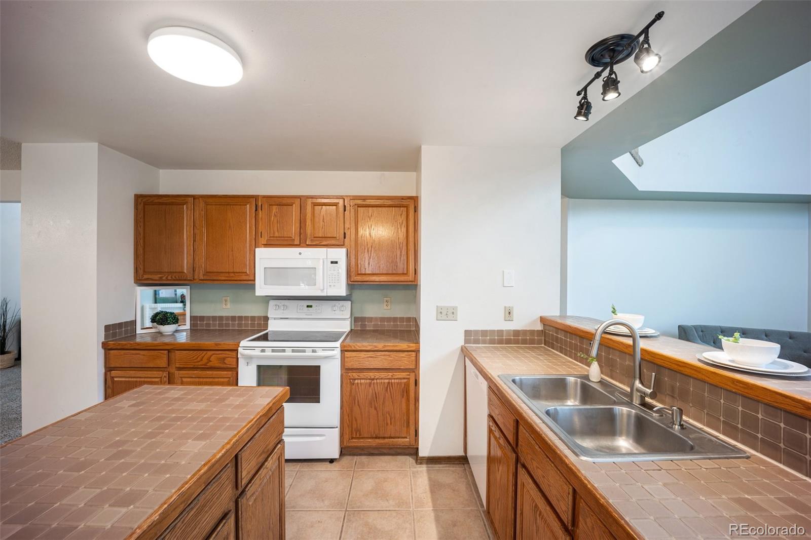 2035 Springcrest Road Colorado Springs, CO 80920 - Photo 14 of 39 a kitchen with a sink stove top oven and cabinets