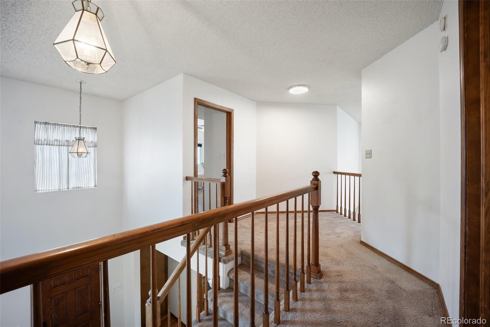 2035 Springcrest Road Colorado Springs, CO 80920 - Photo 20 of 39 a view of a hallway with windows and chandelier