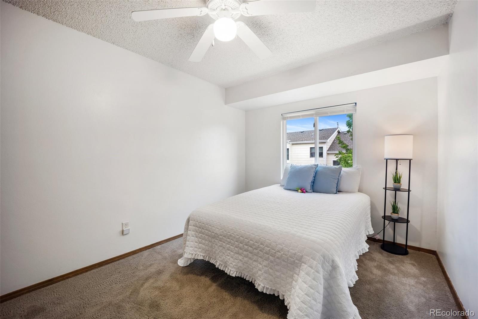 2035 Springcrest Road Colorado Springs, CO 80920 - Photo 22 of 39 a bedroom with a bed and a chandelier