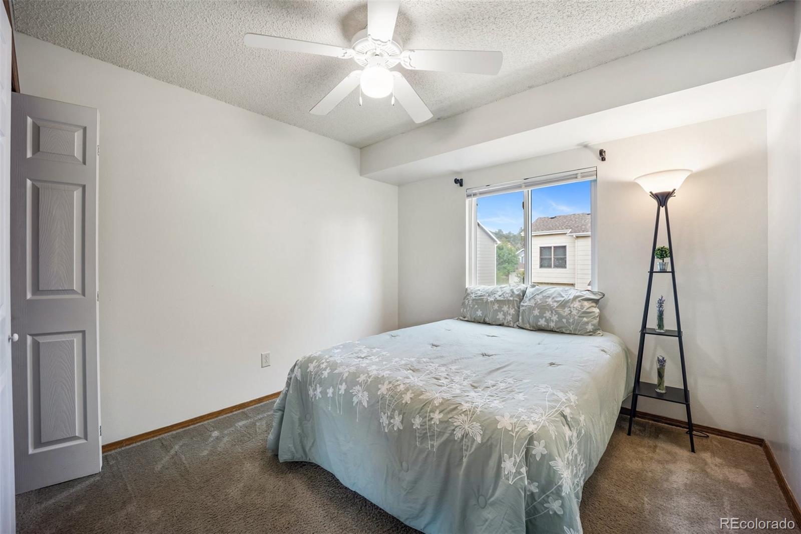 2035 Springcrest Road Colorado Springs, CO 80920 - Photo 24 of 39 a bedroom with a bed and a chandelier