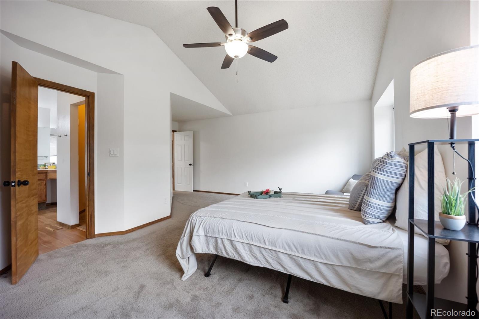 2035 Springcrest Road Colorado Springs, CO 80920 - Photo 27 of 39 a bedroom with a bed and a lamp