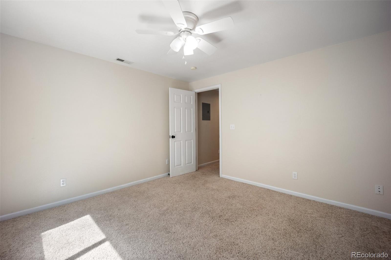 2035 Springcrest Road Colorado Springs, CO 80920 - Photo 39 of 39 an empty room with a chandelier fan and windows