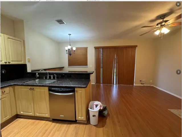 a kitchen with a sink cabinets and wooden floor