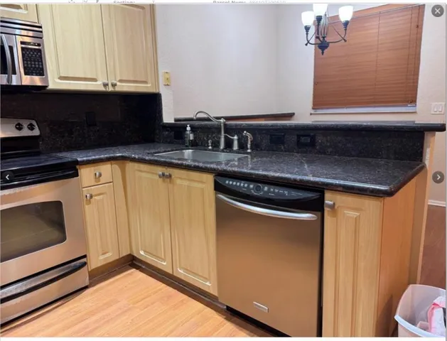a kitchen with granite countertop white cabinets and black appliances