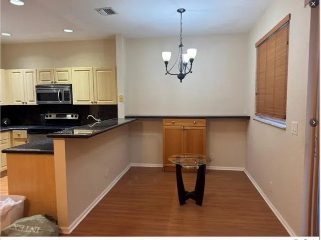 a view of kitchen with stainless steel appliances granite countertop counter space a sink and cabinets