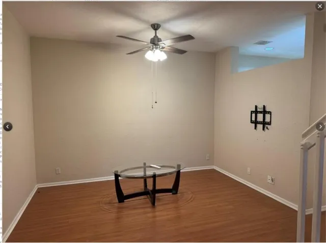 a view of a room with wooden floor and fan
