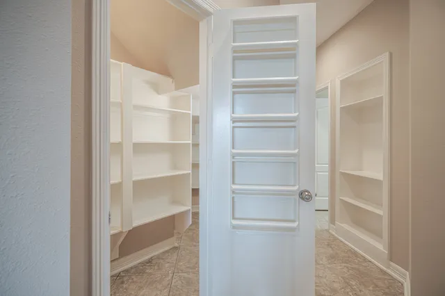 a view of walk in closet with empty racks