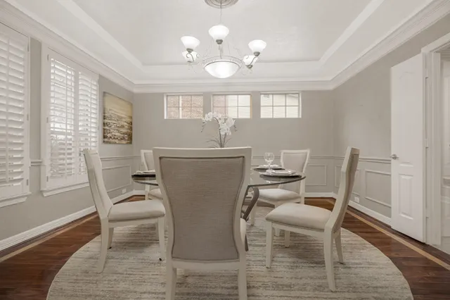 a dining room with furniture a chandelier and wooden floor