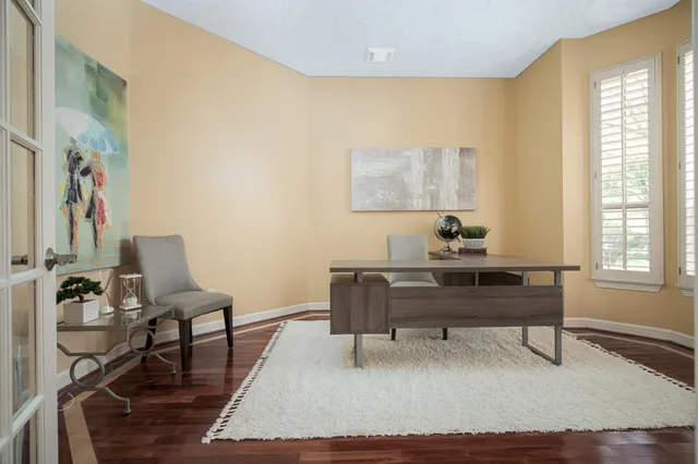 a view of a workspace with furniture and a window