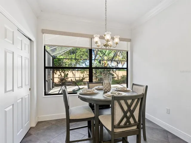 a view of a dining room with furniture a chandelier and wooden floor