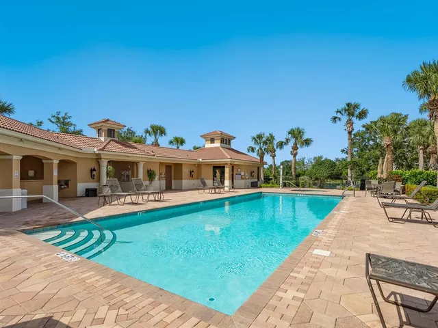 a front view of a house with swimming pool having outdoor seating