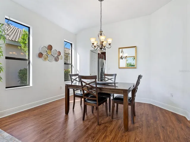 a view of a dining room with furniture a chandelier and wooden floor