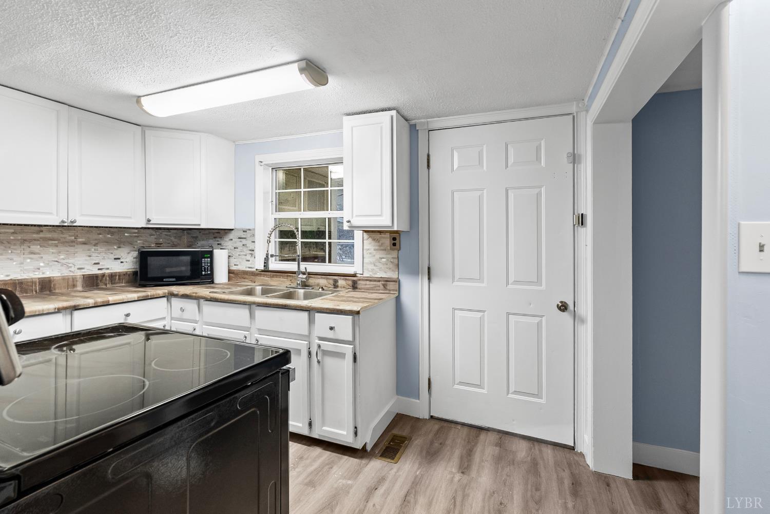 2443 Sunnymeade Road Rustburg, VA 24588 - Photo 11 of 36 a kitchen with a sink stove and cabinets